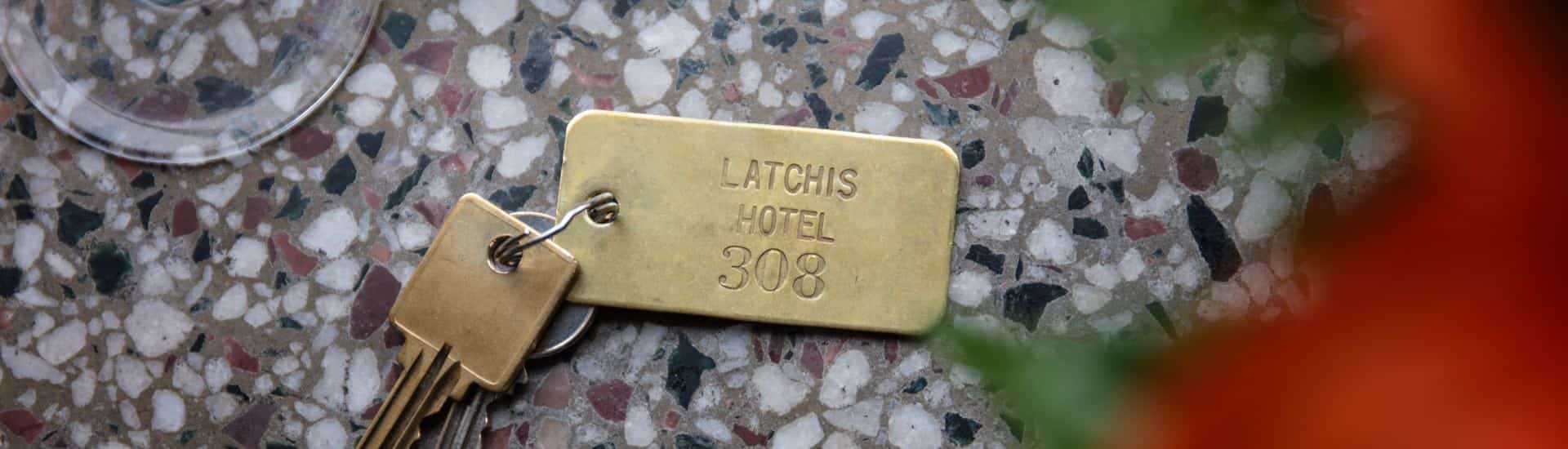 Close up view of old keys on a gold key chain showing Latchis Hotel 308