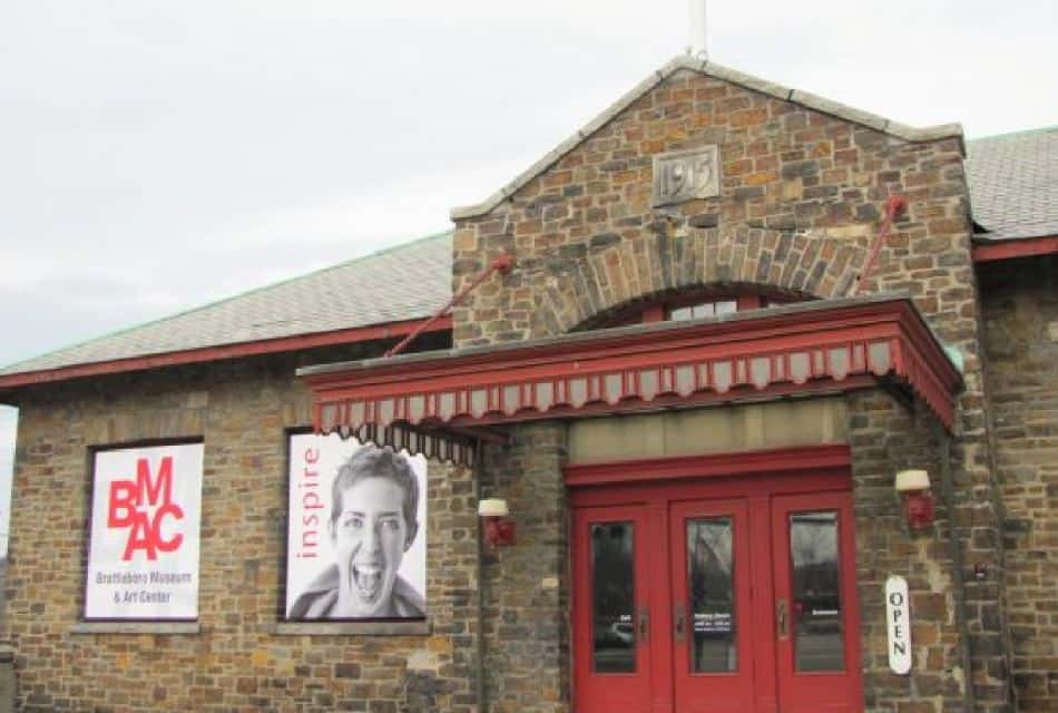 Exterior view of old brick building with red doors