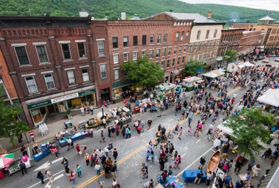 Aerial view of a downtown festival with people and booths lining the streets