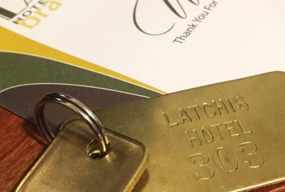 Close up view of old keys on a gold key chain showing Latchis Hotel 303