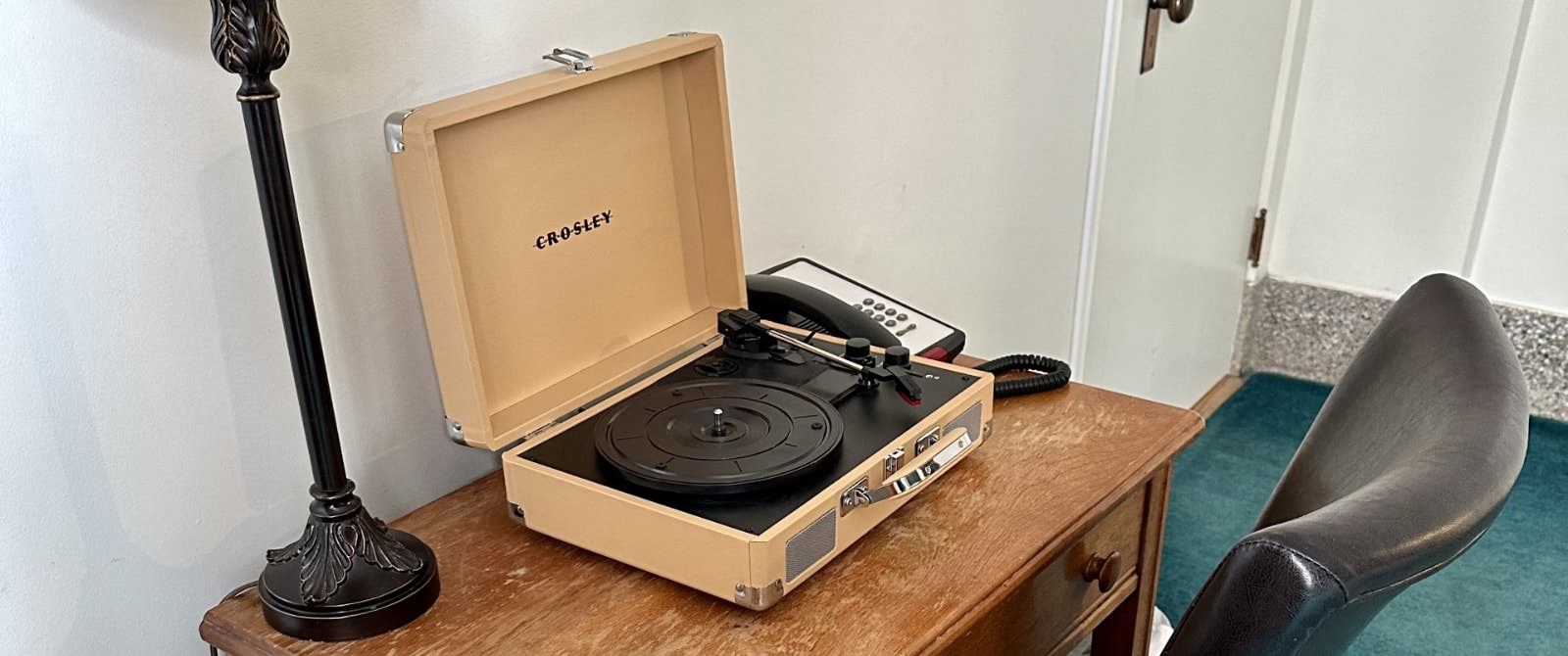 Close up view of wooden desk with record player in tan case