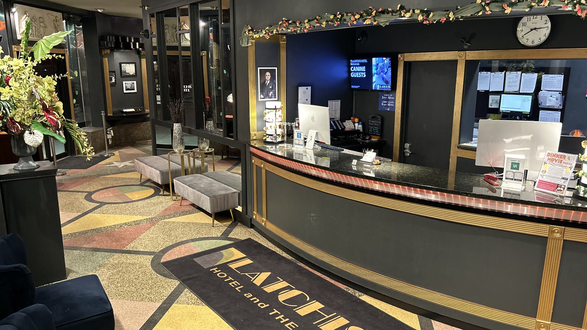 Inside front lobby of hotel with dark gray walls and art deco designed flooring