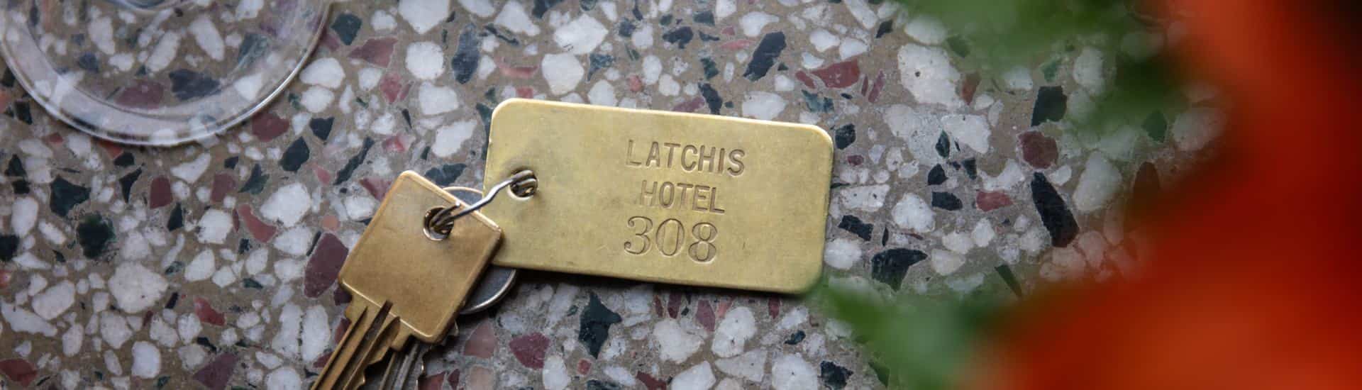 Close up view of old keys on a gold key chain showing Latchis Hotel 308