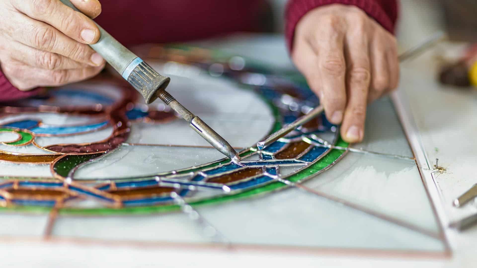 artisan working on stained glass window close up