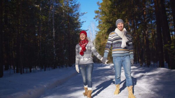 A romantic couple enjoying a winter walk through the woods