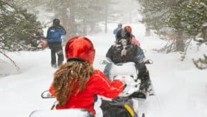 a group of people on a snowmobile tour