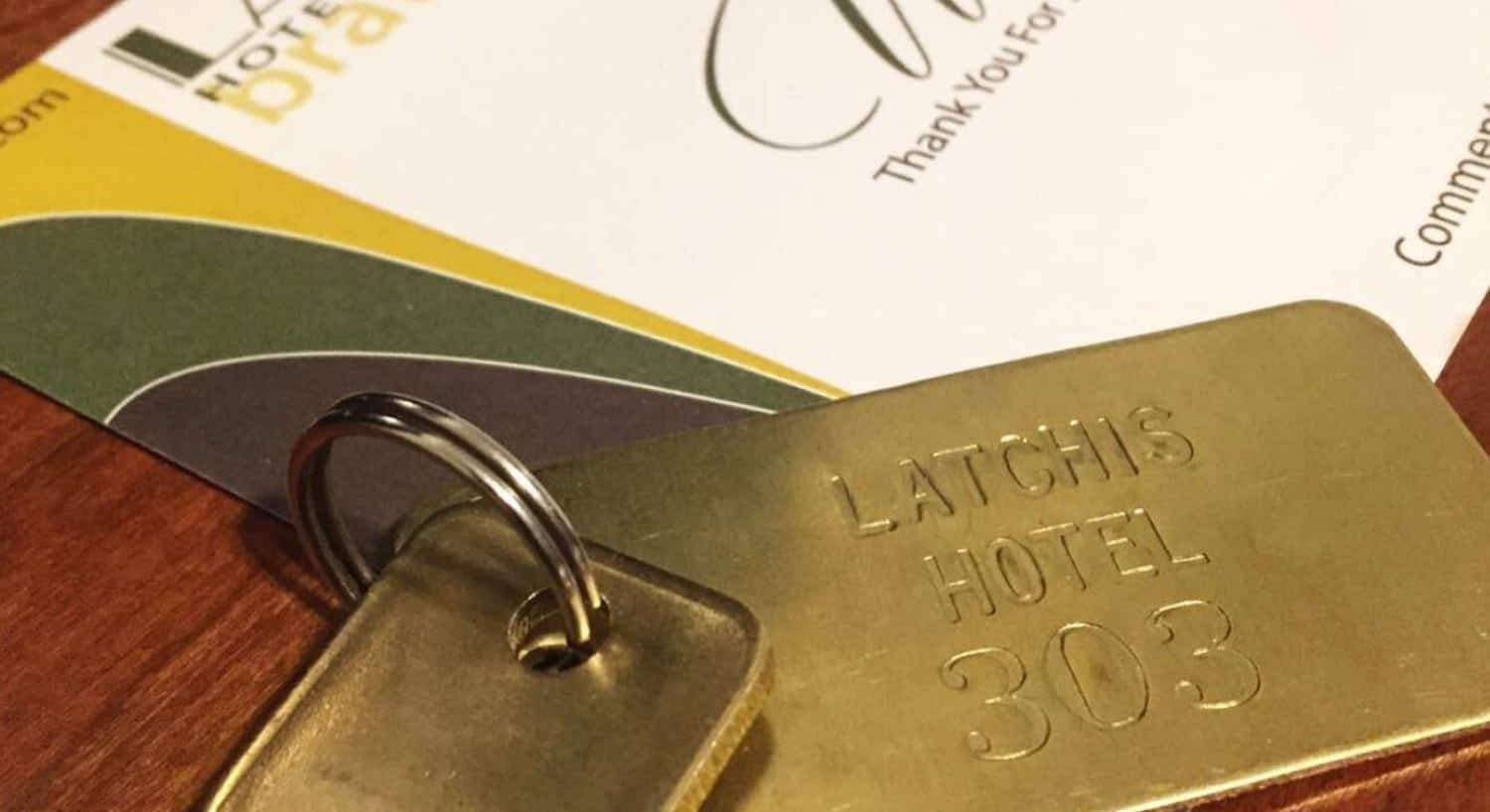 Close up view of old keys on a gold key chain showing Latchis Hotel 303